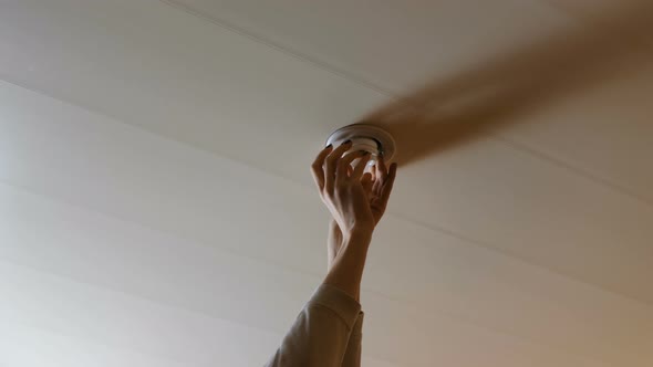 Woman Set the Light Bulb in the Ceiling and Turning on a Light
