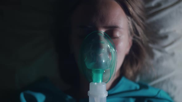 A Female Patient in Medical Mask is Breathing Oxygen Support in a Hospital Next to Heart Rate alt