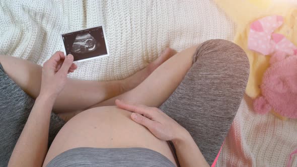 Pregnant Woman Holding Ultrasound Image
