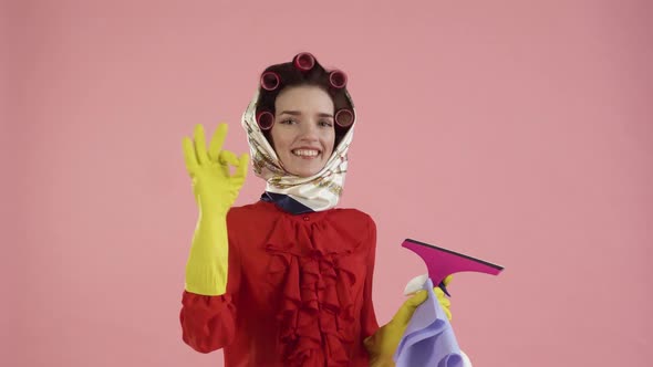 A Young Woman in a Blouse and with a Scarf on Her Head Shows the OK Gesture