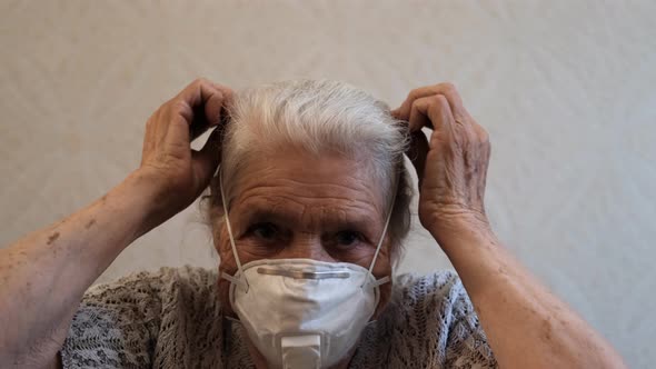 Slow Motion Portrait of Senior Woman Puts on a Protective Respirator.