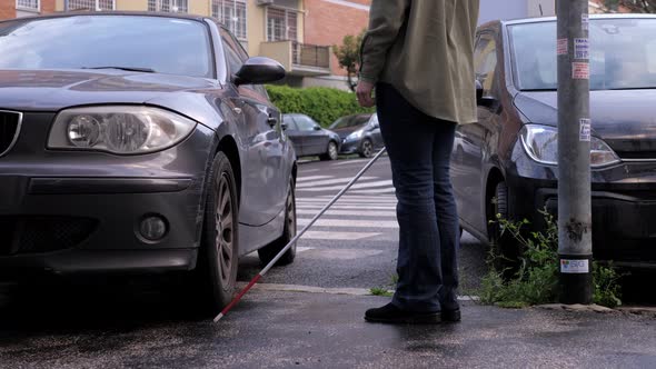 woman with a disability has to get around a car parked on the sidewalk alt