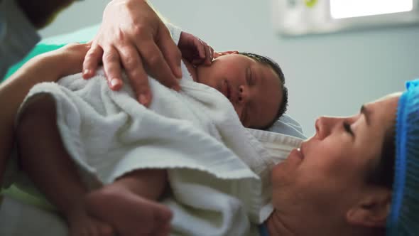 Close-up of Caucasian couple holding their newborn baby in operation theater alt