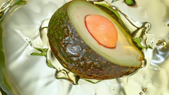 Super Slow Motion Shot of Fresh Avocado Falling and Splashing Into Oil at 1000 Fps alt