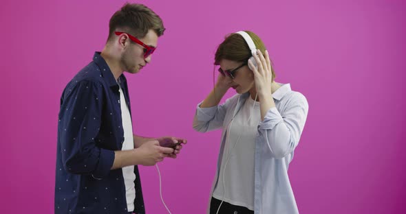 Happy Woman or Teenage Girl in Headphones Listening to Music From Smartphone Her Boyfriend is