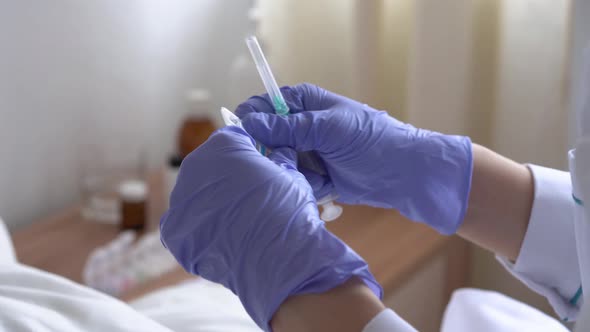 Close Up of Female Doctor or Nurse Hands in Blue Protective Gloves Draws Vaccine From Ampoule Into