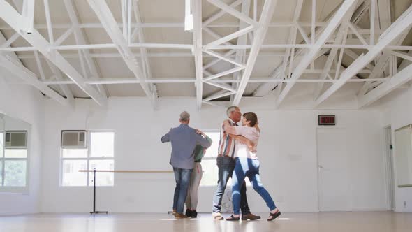 Caucasian senior couples spending time together in a ballroom and dancing