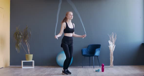 Young Sporty Woman Exercising with Skipping Rope alt