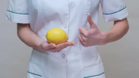 Nutritionist Doctor Healthy Lifestyle Concept - Holding Organic Lemon Fruit alt