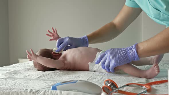 Nurse Wipes the Newborn's Body with Cleansing Wipes. Hygiene Concept, Cleanliness alt