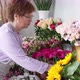 Serious female entrepreneur preparing flowers for new busy working day in floristic street shop. - VideoHive Item for Sale