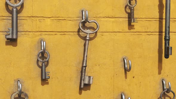 Animation of a key hanging on the hook with other keys around. Yellow wall. 4kHD alt