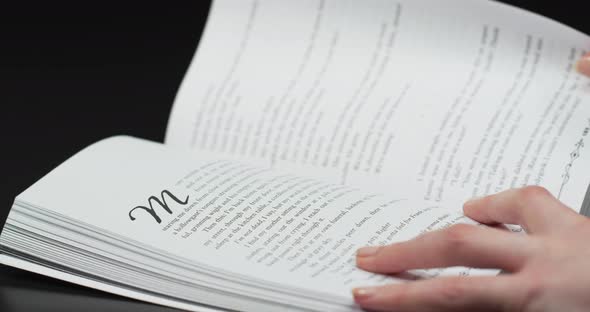 Hands turning the pages of a book alt