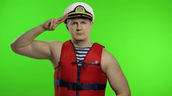 Muscular Sailor Man Works As Lifeguard at Beach Salutes with Hand To Camera alt