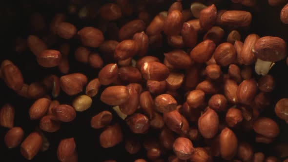 Peanuts On A Black Background Are Tossed In The Air In High Speed alt