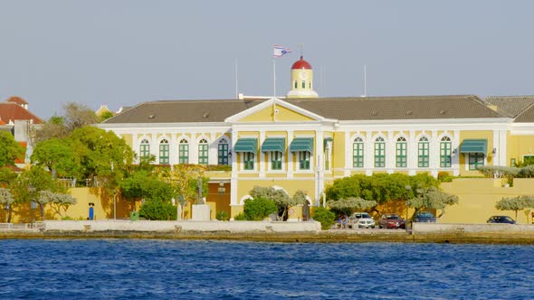 The House Of Parliament In Curacao With Yellow Exterior Facade - wide shot alt