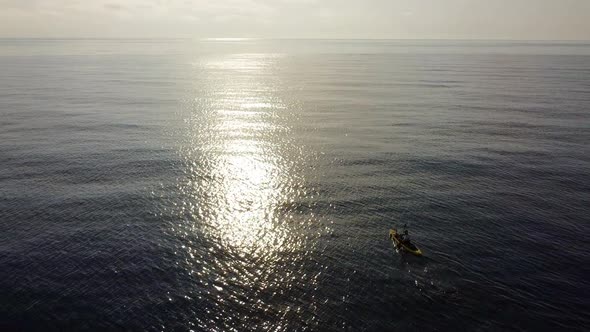 Fisherman trolling in kayak at mediterranean sea aerial drone view in middle of ocean. alt