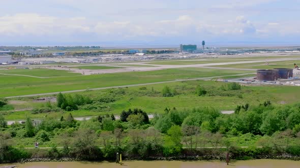 Evergreen Airport Field Of YVR- Vancouver International Airport With A Landing Plane In The Backgrou alt