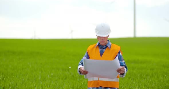 Male Engineer Explaining While Holding Blueprint alt