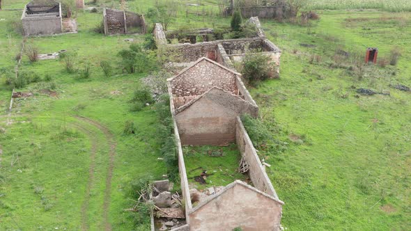 Roofless derelict buildings in an abandoned farm deserted due to rural flight - migration to cities. alt