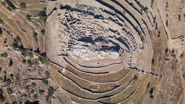 Aerial bird's eye video taken by drone of iconic prehistoric settlement of Skarkos, Ios island, Cycl alt