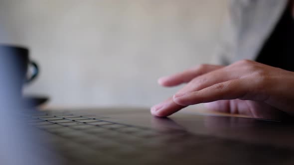 Closeup a woman working and touching on laptop computer touchpad on the table