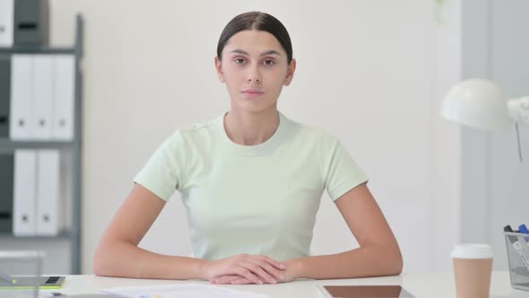 Serious Young Latin Woman Looking at Camera in Office alt