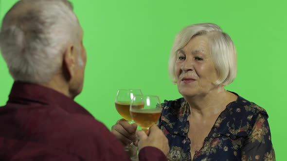 Senior Aged Woman Drinking Wine with a Elderly Man Companion on Chroma Key alt