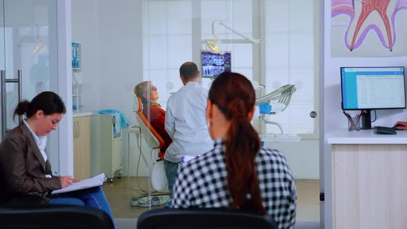 Patients Sitting on Chairs in Waiting Room of Stomatological Clinic Filling alt