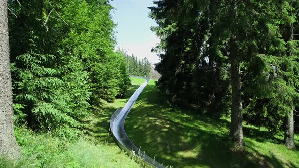 Aerial view of bobsleigh track on green mountain hill