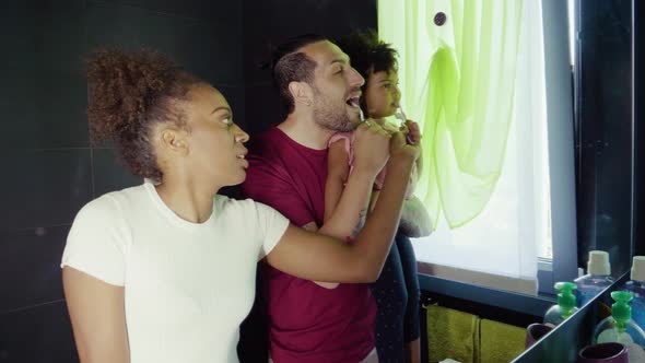 Family brushing their teeth in bathroom alt