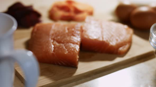 Closeup of Fresh Salmon Fillet on a Wooden Board Ready to Be Prepared alt
