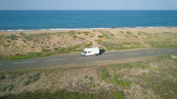 Side View of White Bus Driving Along Beautiful Sea Road in Sunny Day. Alepu, Bulgaria alt