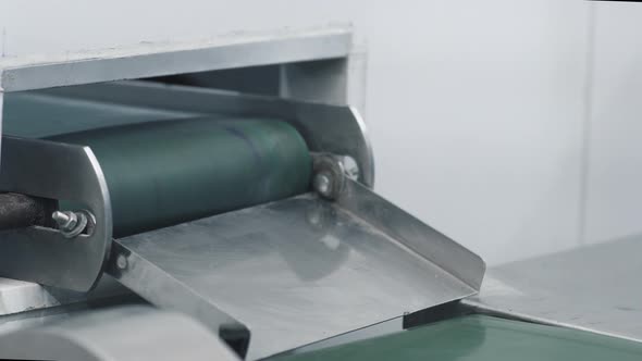 Conveyor belt pulls out the packages of medicine pills checked by hand for their quality alt