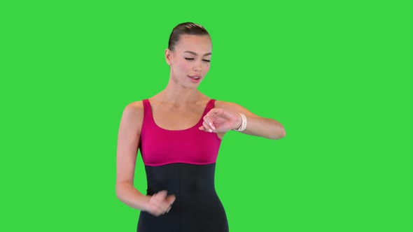 Running Woman Jogger Using Smart Watch While Walking on a Green Screen Chroma Key