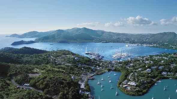 Drone descends to the yachts in bay of the coastal city at Falmouth Harbour in Antigua and Barbuda alt
