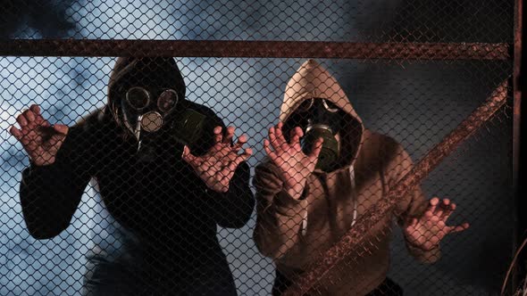Two People in Gas Masks Trying to Get Out of the Burning Building alt
