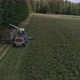 Aerial view of two Combines harvesting, trucks and tractor on grass field. 33 - VideoHive Item for Sale