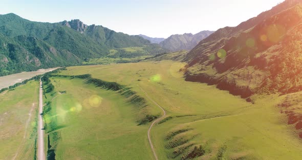 Aerial Rural Mountain Road and Meadow at Sunny Summer Morning. Asphalt Highway and River. alt