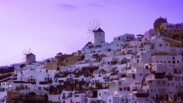 Beautiful timelapse of sunset on island of Santorini, Greece in violet and with famous windmill