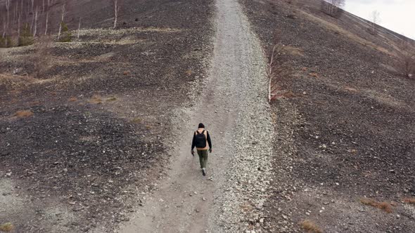 Aerial View of a Traveler Walking on a Mountain Against the Background of a Valley and Mountains alt