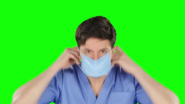 Doctor Puts on Protetcive Mask, Green Screen alt