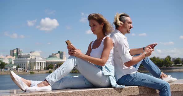 Modern Addictions  a Man and a Woman Sit Buried in Smartphones During a Date alt