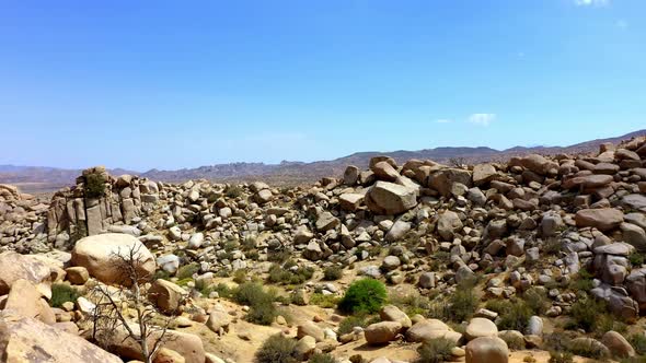 Drone shot flying towards the rocks of Boulder Gardens in Pioneertown, California. alt