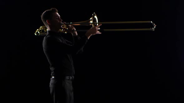 Trumpeter Plays on Wind Instrument Tranquil Melody. Black Studio Background alt