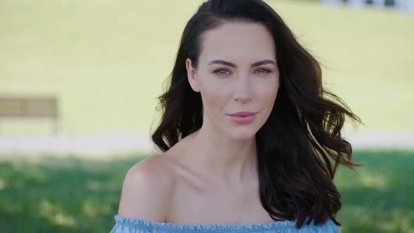 Beautiful Woman, Fashion Model with Long Brown Hair Sitting on Green Grass alt