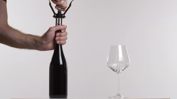 A Man Open a Bottle of a Red Wine