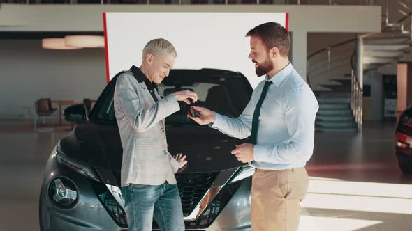 Positive Female in Smiling for Camera and Demonstrating Keys While Standing Near alt