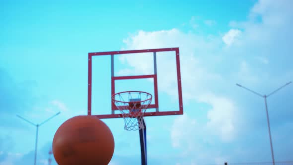 Player Spins a Basket Ball on Finger on a Basketball Court at Sunset