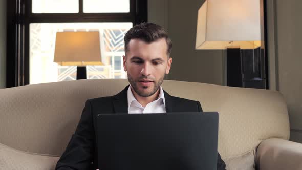 Portrait of Happy Business Man Enjoys Success on Laptop in Hotel Restaurant alt